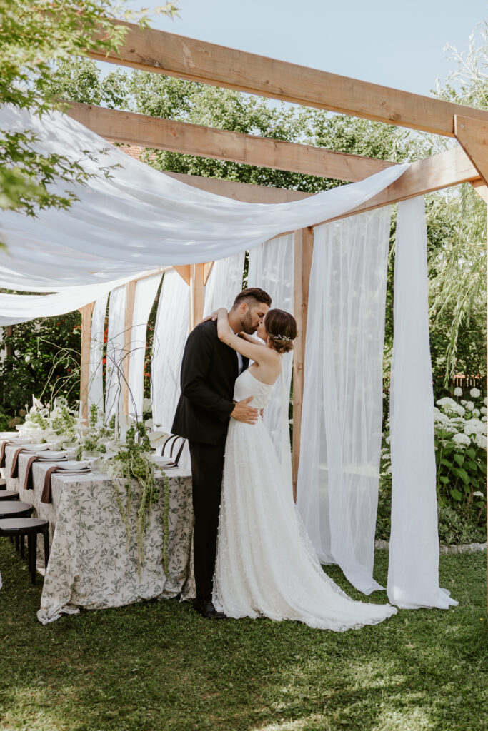 Exklusive Hochzeiten in Bayern – Warum Ästhetik hier eine Herausforderung ist 3 Küssendes Brautpaar auf Toskana Style Hochzeit.